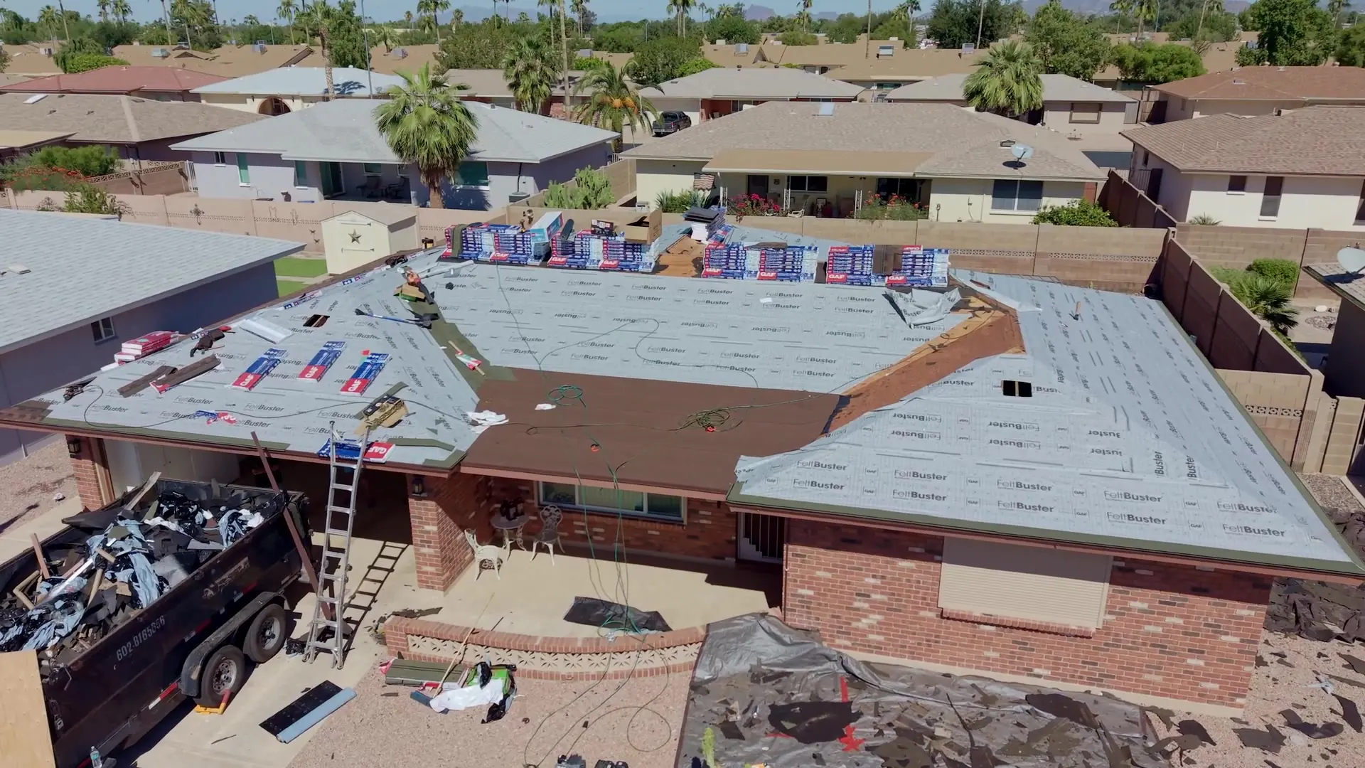 Drone view of a roof covered in new underlayment with shingles staged