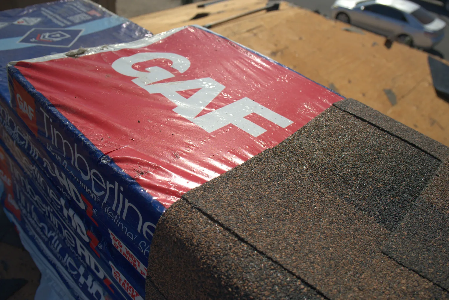 Bundles of GAF Timberline HDZ shingles staged on a roof deck